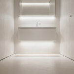 Modern small bathroom featuring a floating vanity with a clear floor space beneath, enhancing visual openness and showcasing subtle under-vanity lighting.